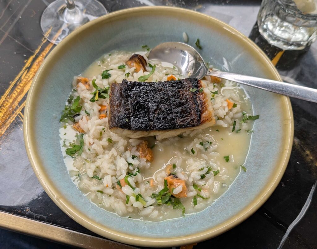 A fish dish, perhaps hake, on a risotto.