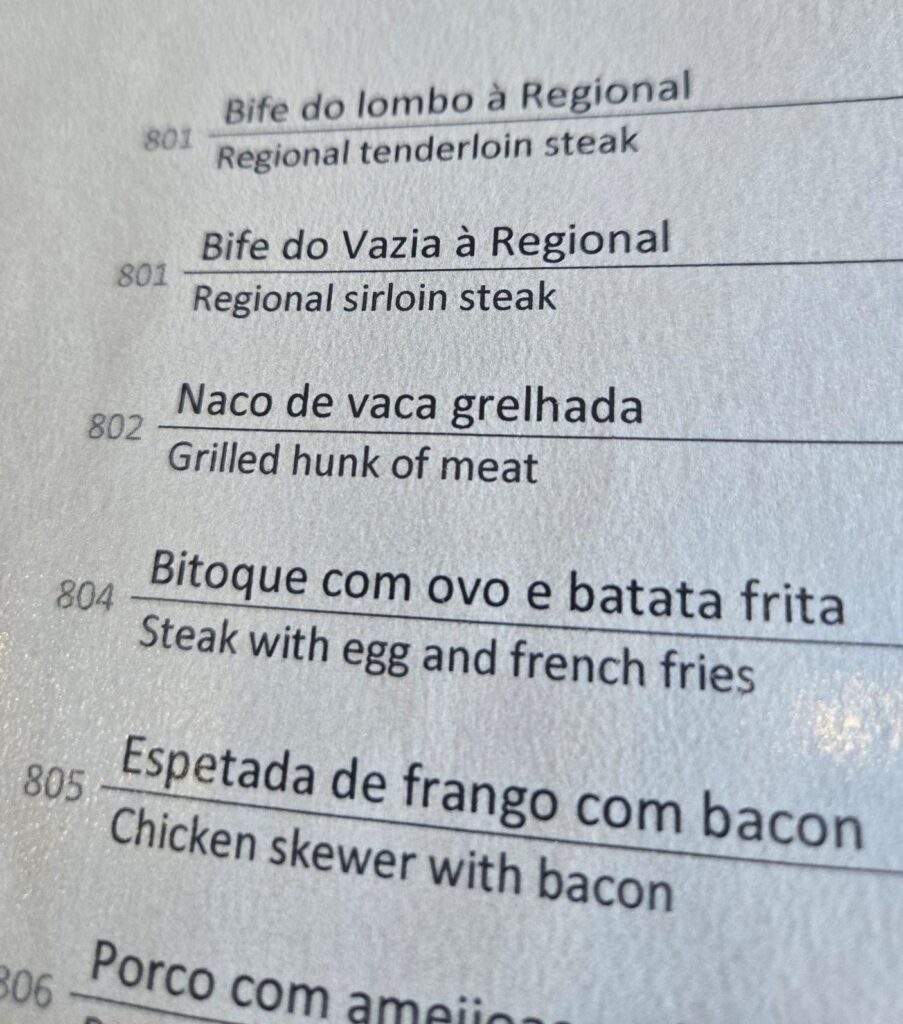 A menu from a restaurant named Mariserra.  The third item is "Naco de vaca grelhada" which is translated as "Grilled hunk of meat."
