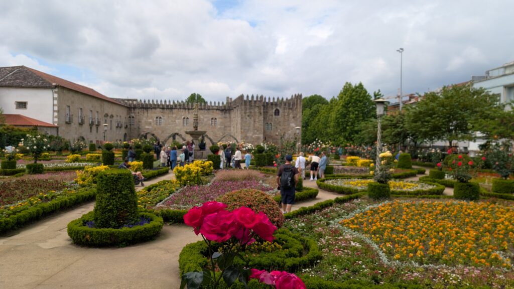 Photo of the Jardim de Santa Barbara in May, flowers in foreground, old library in background.