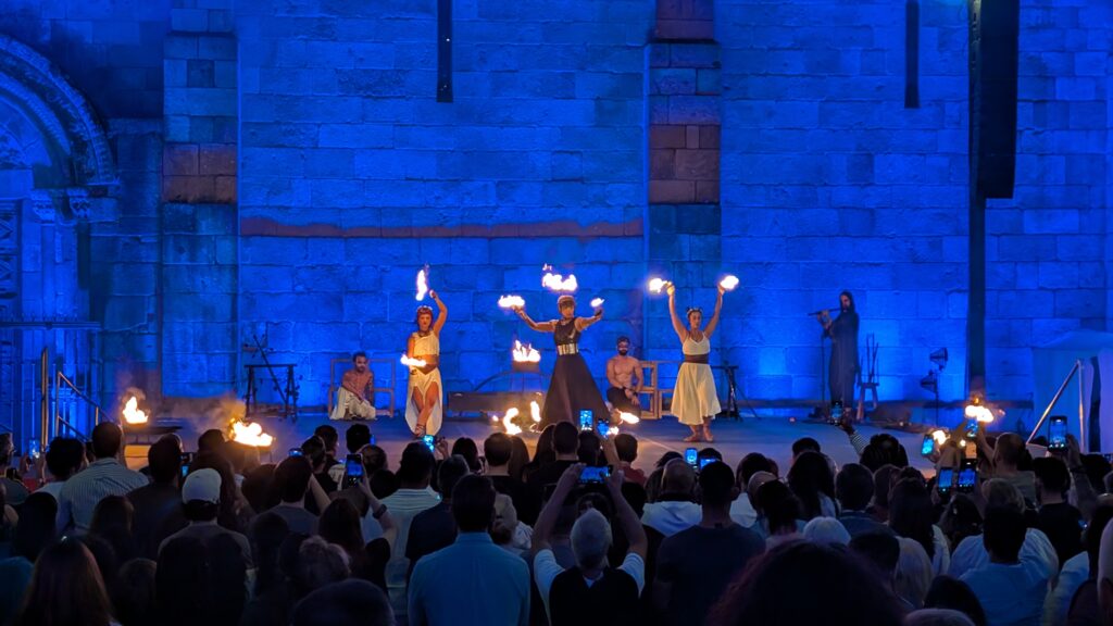 Three fire spinners, one with a headdress of fire.
